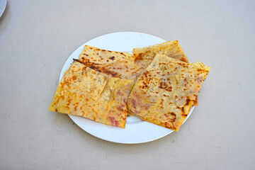 Freshly baked appetizing Turkish tortillas - Gozleme with spinach, cheese  on a white board. Space for text. Handmade Turkish traditional pastries. Ispanakli, otlu peynirli gozleme. Tahinli Katmer