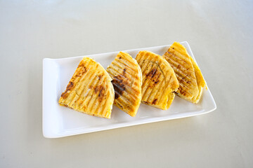 Freshly baked appetizing Turkish tortillas - Gozleme with spinach, cheese  on a white board. Space for text. Handmade Turkish traditional pastries. Ispanakli, otlu peynirli gozleme. Tahinli Katmer