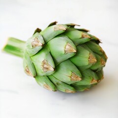 Obraz premium Freshly harvested artichoke on a light background showcases its unique texture and vibrant color