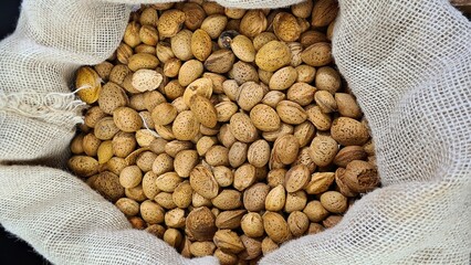 The ripened in-shell nuts are filled into large bags for sale at the city market