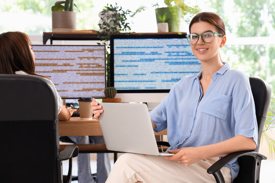 Female programmer working with laptop in office