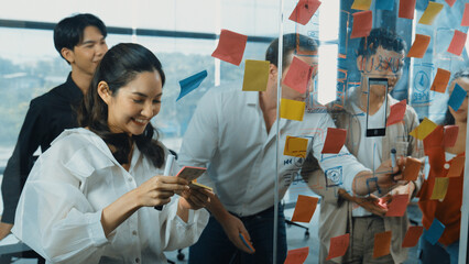 Portrait of professional business team brainstorming marketing idea by using sticky notes to share...