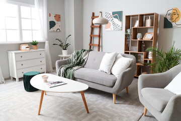 Interior of light living room with wooden ladder, sofa and shelf unit