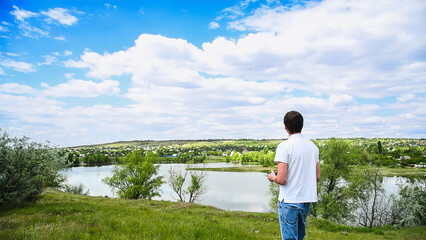 Young man controls a drone using a remote control