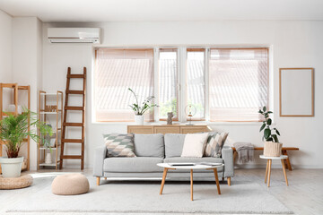 Interior of light living room with wooden ladder, sofa and plants
