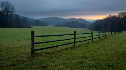 Dawn over valley pasture, split rail fence, misty hills