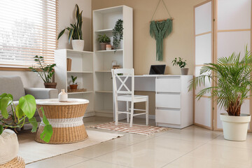 Interior of living room with green houseplants, sofa and tables