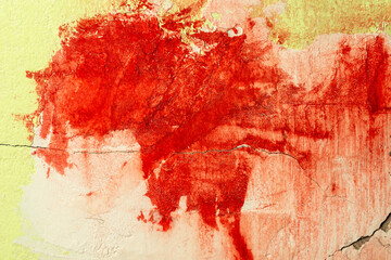 Green damaged plaster on concrete wall, old plaster needs repair. Abstract red paint strokes on...