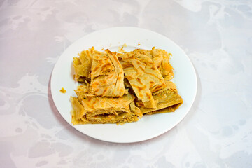 Freshly baked appetizing Turkish tortillas - Gozleme with spinach, cheese  on a white board. Space for text. Handmade Turkish traditional pastries. Ispanakli, otlu peynirli gozleme. Tahinli Katmer
