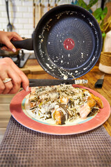 the woman puts the cooked salmon on the platter
