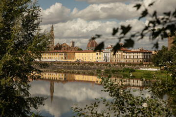 Florence, Italy: city view from the other side of river Arno with the reflection of the buildings...