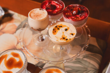 Different fruit cream cups on a glass tray.