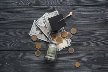Graduation hat with money on dark wooden background. Student loan concept