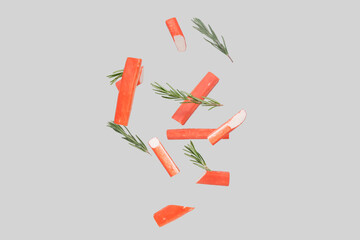 Tasty crab sticks and rosemary flying on grey background © Pixel-Shot