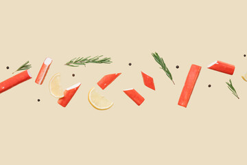 Cut tasty crab sticks with rosemary, peppercorns and slices of lemon flying on green background © Pixel-Shot