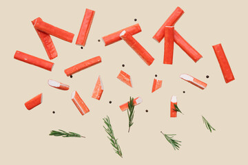 Tasty crab sticks with rosemary and peppercorns flying on green background © Pixel-Shot