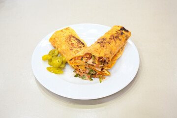 Lavash doner kebab ( soslu kasarli zurna doner durum )  or shawarma sliced in plate isolated.  Tavuk Et Doner Durum. Hatay Iskenderun usulu bazuka tavuk doner durum. 