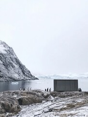  penguins on the rocks in front of glaciers and snow-covered mountains