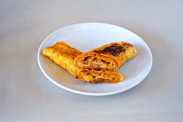 Lavash doner kebab ( soslu kasarli zurna doner durum )  or shawarma sliced in plate isolated.  Tavuk Et Doner Durum. Hatay Iskenderun usulu bazuka tavuk doner durum. 