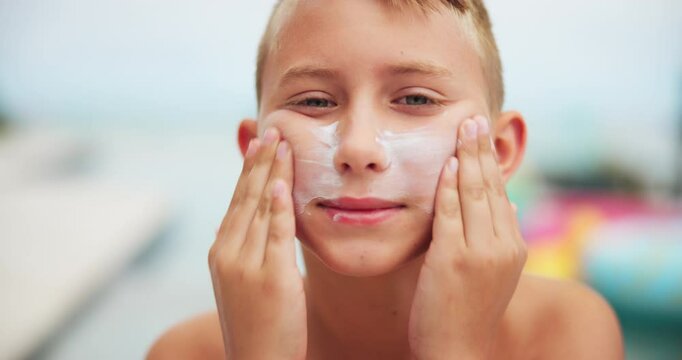 Face, kid and boy with sunscreen outdoor of skincare protection, prevent sunburn and summer holiday. Portrait, child and cream application for facial wellness, spf treatment and dermatology hydration