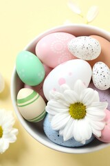 Easter decor concept. Top view photo of colorful eggs in a bowl on pastel background