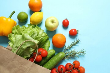 Paper bag, vegetables and fruits on color background