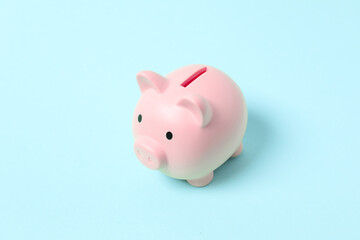 Piggy coin bank on colored background for money savings, financial security or personal funds concept.