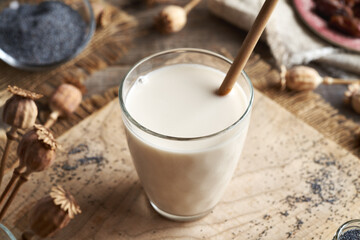 Vegan poppy seed milk in a glass cup with bamboo straw. Zero waste.