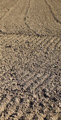 brown tilled ground in the field ready to sow cereal in the spring