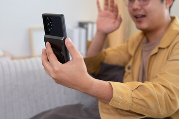 Male hand holds cell phone upright to record video.