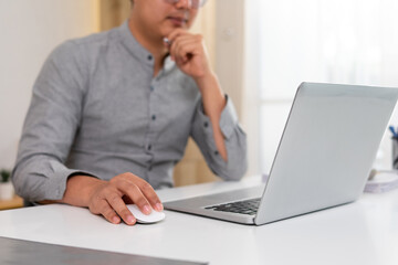 Young man contemplating work planning on laptop