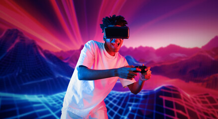 Teenager holding joystick and wearing VR goggles while enjoy playing games at neon abstract...