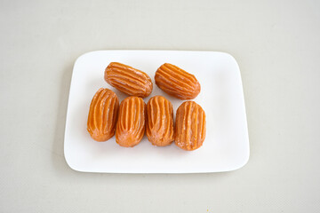 Traditional Turkish dessert tulumba, tulumba tatlisi in a plate served with tea. Tulumba (or...