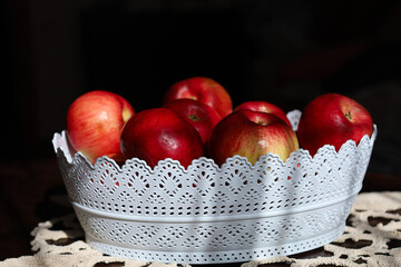 A white basket filled with red apples