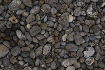 Textured photo of carved pebbles on a beach in Etretat, France.