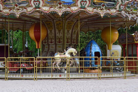 A vintage carousel with ornate decorations, featuring painted panels of scenic landscapes. Nostalgic Carousel with Scenic Panels