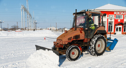 Samara, Chapaevsk, Russia-February.20.2018: Snow plow truck cleaning forecourt area streets Winter snow removal concept city landscape background horizontal
