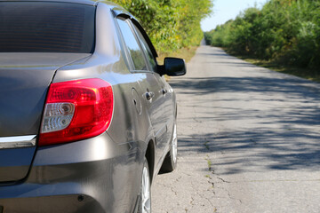 a car on the road, a parked car on the road leading away into the distance.