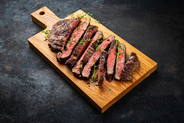 Barbecue grilled dry aged meat wagyu beef flank steak cut as tagliata on wooden board with text space