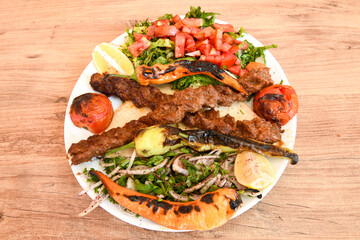 Grilled Turkish Adana, Urfa  Kebab with grilled vegetables, onion and rice on plate. Urfa, Adana durum.
