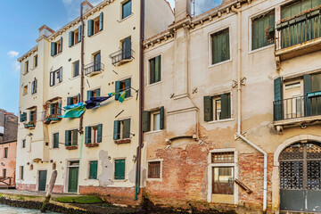 Facade of Old buildings in inland canals which are the waterways of Venice, Italy, 2019