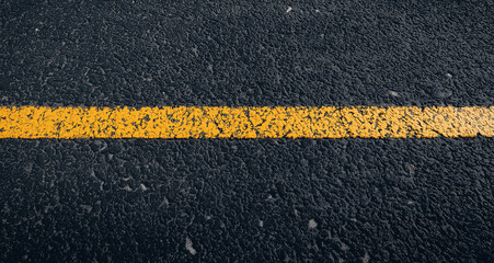 Fototapeta premium A top-view of a black asphalt road texture, featuring a fresh, smooth tarmac surface with small rocks scattered across it. This background is perfect for a road or car track-themed banner or design pr