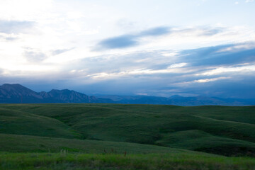 Green rolling hills with mountains in the distance