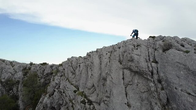 a man traversing a rocky terrain in Sainte Baume, France