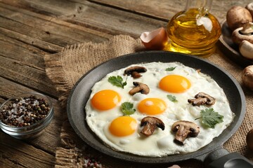 Tasty fried eggs with mushrooms and parsley served on wooden table, closeup