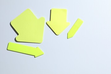Yellow paper arrows on white background, flat lay. Space for text