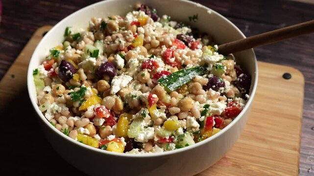 Mediterranean dense bean salad with chickpeas, feta,  garbanzo beans, parsley, onion, olives  and lemon dressing