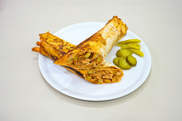 Lavash doner kebab ( soslu kasarli zurna doner durum )  or shawarma sliced in plate isolated.  Tavuk Et Doner Durum. Hatay Iskenderun usulu bazuka tavuk doner durum. 