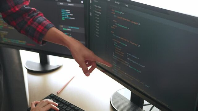 Slow motion back end or software developer manager supervising his team on new application program development on debugging and solving complex code algorithms on monitor. Burgeoning