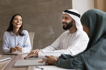 Group of professionals engaged in positive, collaborative meeting. Arabian businessman dressed in...
